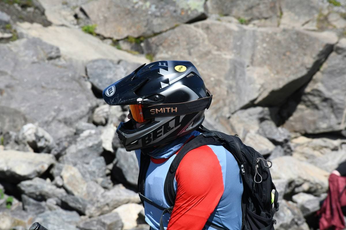 A climber scaling a rock wall wearing climbing gloves