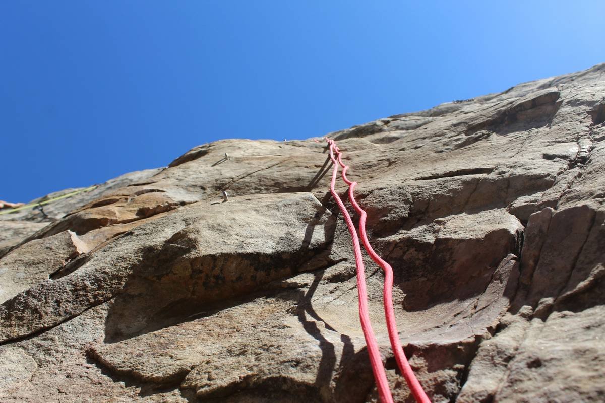 A climber wearing gloves while ascending a rock wall, symbolizing motivation and resilience.