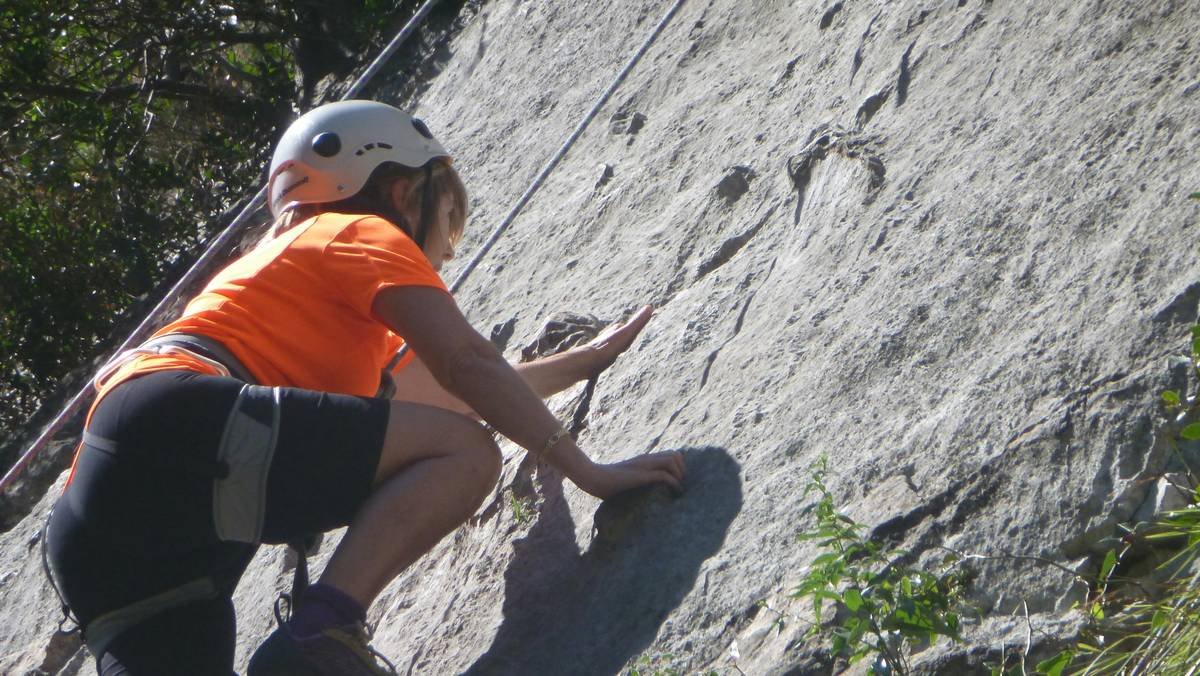 A person holding climbing gloves, highlighting features like padded palms and breathable fabric