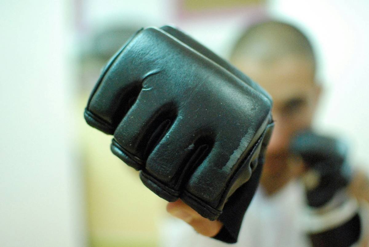 A person wearing climbing gloves while lifting weights.
