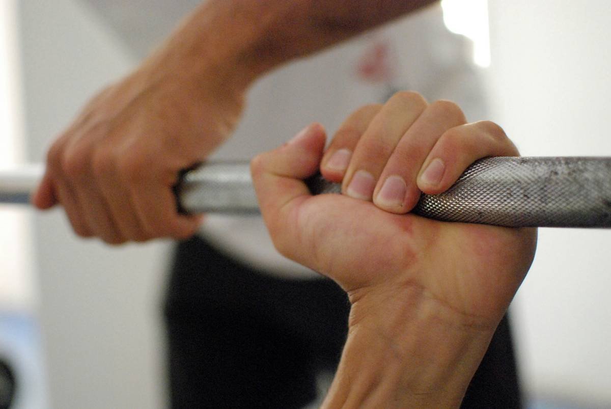 A woman wearing grip gloves while doing push-ups, showing proper wrist alignment