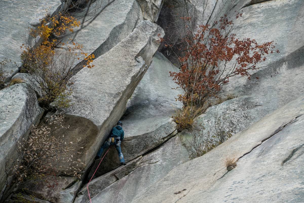 A person cleaning their climbing gloves with a brush and soap.